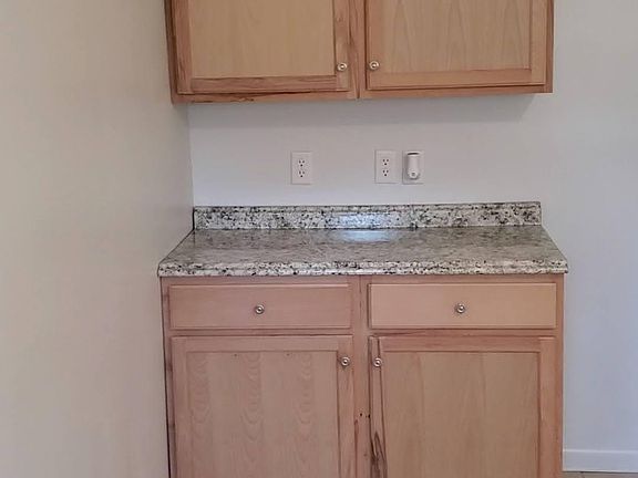 New kitchen cabinets and countertops -Refrigerator will go to the right of cabinets.