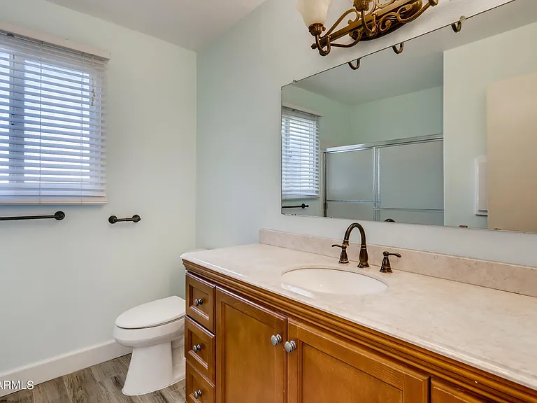 Large bathroom in hallway has plenty of storage & pull out shelves under sink.