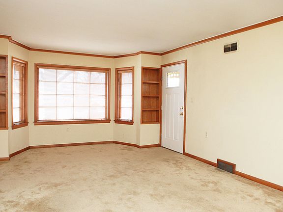 A view looking towards the entryway. What a great bay window and surrounding built-ins! All the trim and baseboards are in their original state.