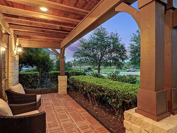 PEACEFUL BRICK LINED FRONT PORCH WITH CEDAR LINED CEILING.