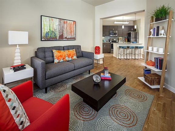 Living room with kitchen view, wood-style flooring, and cable ready
