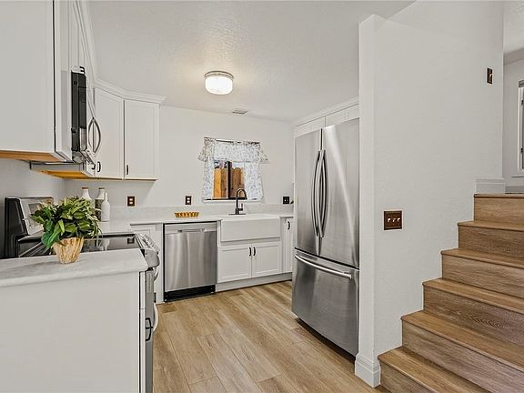 Modern kitchen cabinets with stainless steel appliances and a farm-style sink