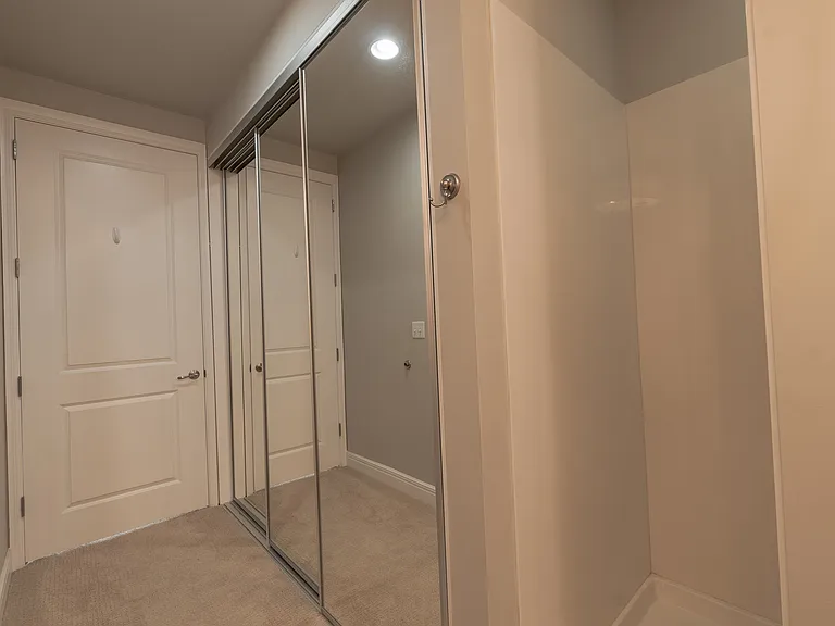 Bathroom Entrance and Mirrored Closet Space