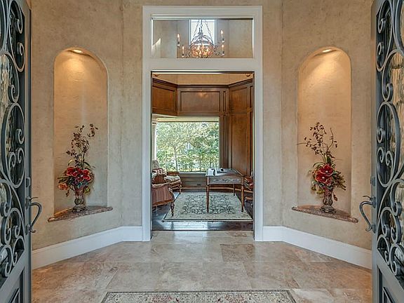 Double doors with glass inlay lead to the two story entry way with decorative art niches.