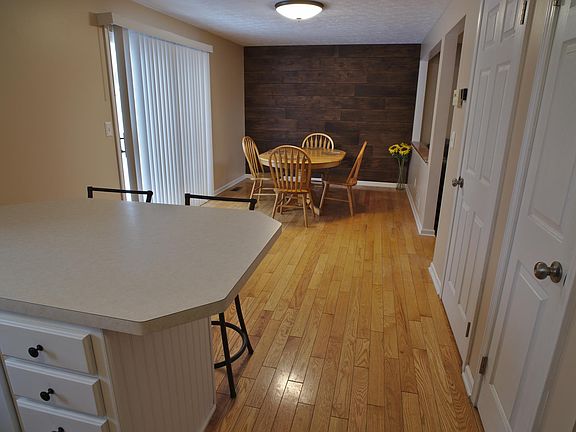 Looking into the dining area. Taking the sliding glass door to the left will lead you to the fenced in backyard. Taking the second door on the right will lead you downstairs to the partially finished basement where you will find the washer and dryer.