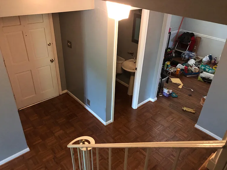 Foyer from stairway landing, front door, powder room and view into dining room.