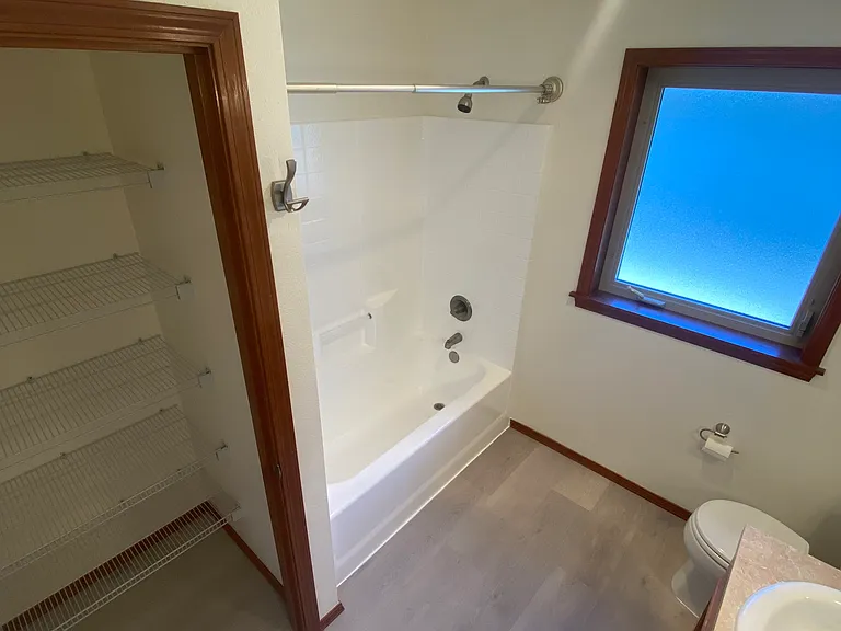 3rd Floor _ Primary bathroom with a dual-sink vanity, updated flooring, a large linen closet, and a built-in heat lamp.