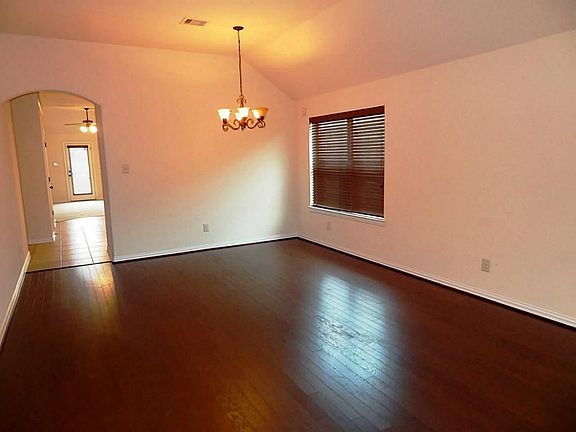 Rich wood laminate floors in the combined formal dining and living room.