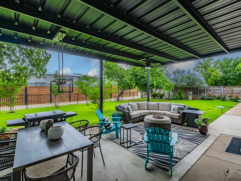 Fully furnished covered patio with fire pit and sectional seating.