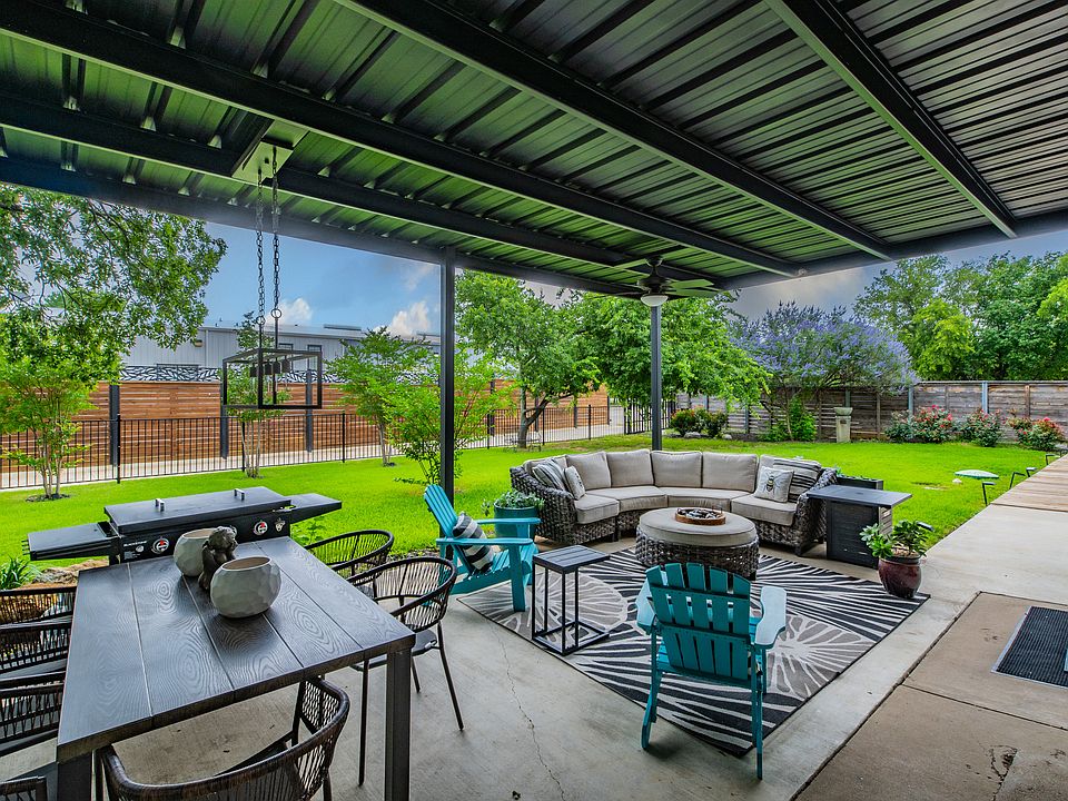 Fully furnished covered patio with fire pit and sectional seating.