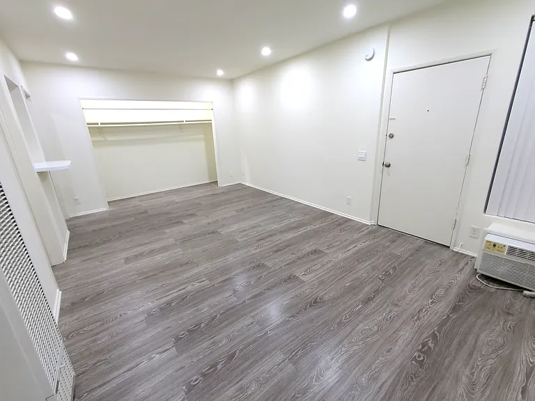 living room and front entrance with a large coat closet close to the kitchen an breakfast nook area
