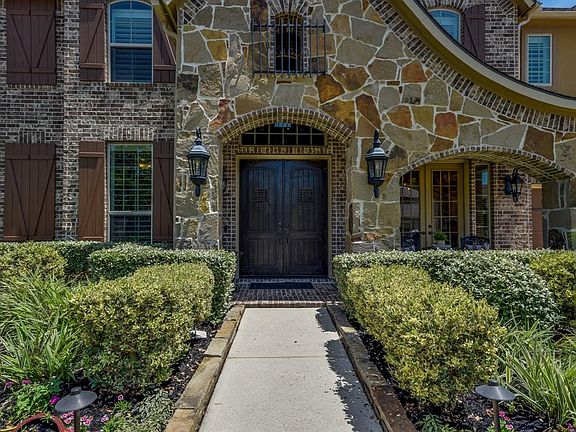 Beautiful curb appeal, stunning stacked stone elevation. Beautiful wrought iron lanterns frame the arched entry to double wood front doors.
