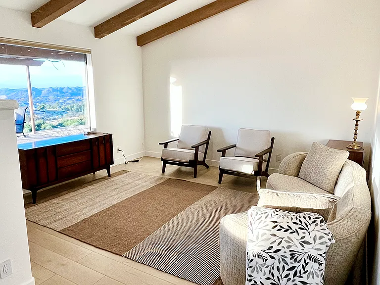 To the right of the dining space is another sunken living room with a huge picture window looking out at the mountains and lake