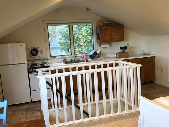 Efficient galley kitchen with full size fridge, pots, pans and dishes.