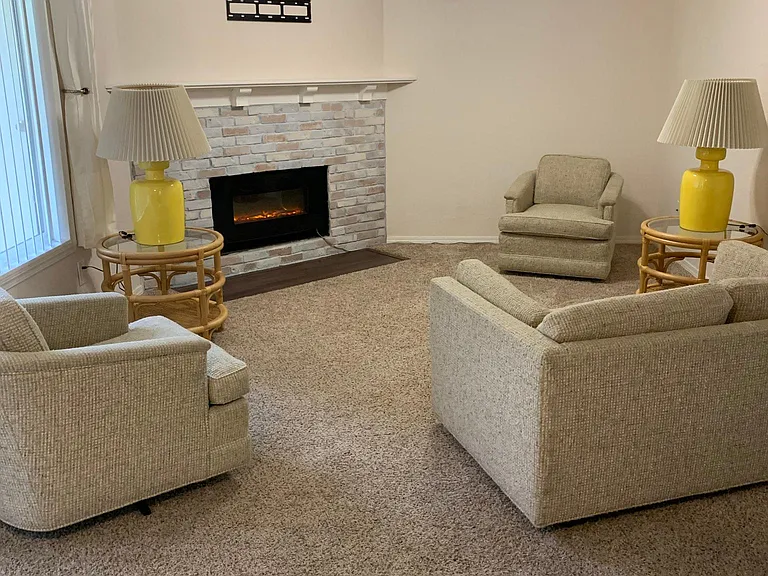 Living room with couch/2chairs/2tables and lamps. Fireplace wall can hold a max 42" TV. Cable ready. Window looks out on patio/green area.
