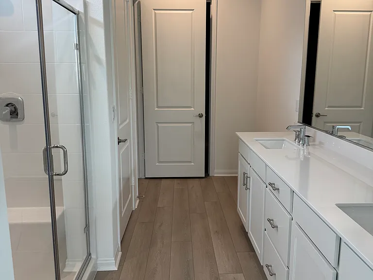 Primary bathroom with marble countertops and dual sinks