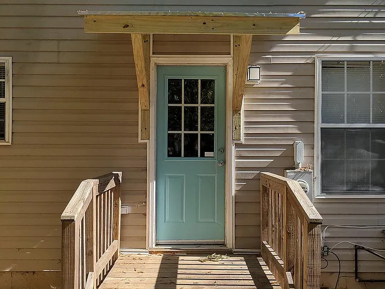 Back porch leading to a fenced in yard