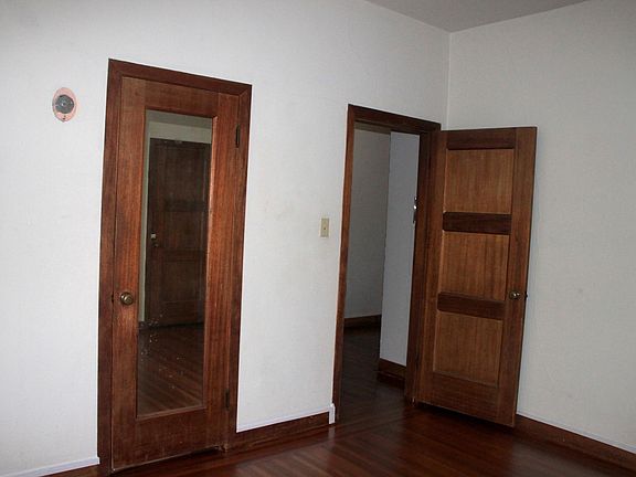 Bedroom w/mirrored closet door. Bedroom door opens to entryway.