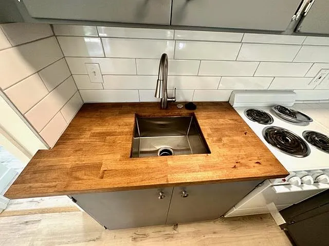 New butcher block countertop with heavy gauge undermount stainless sink.