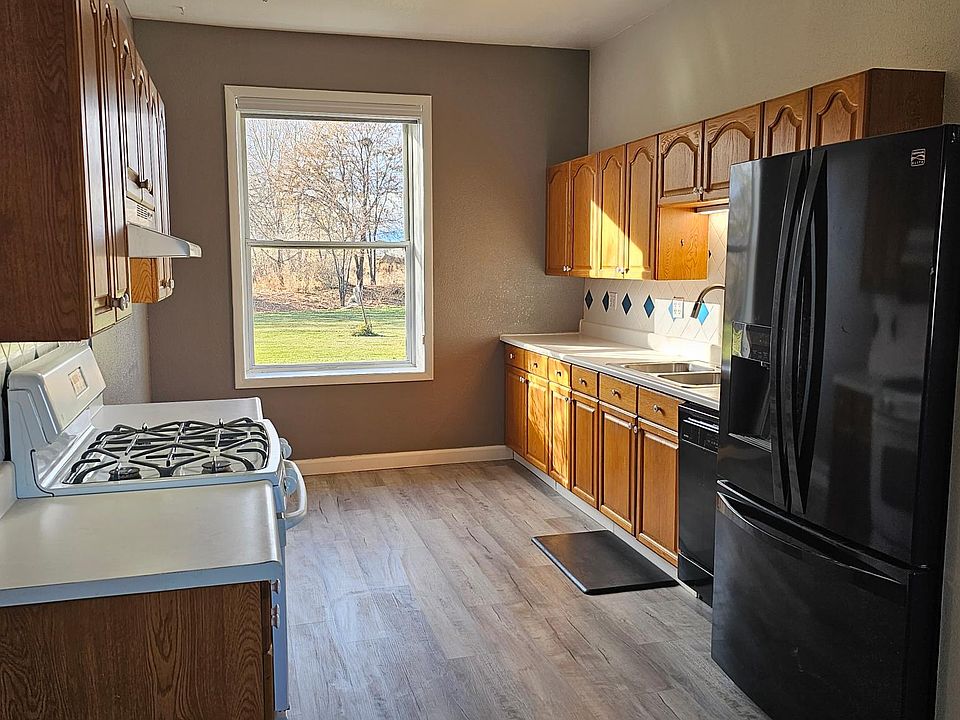 Large Kitchen

Oak Cabinets
Black 36-inch Refrigerator
Black Dishwasher
Window view of the large backyard
Area for a table near this window