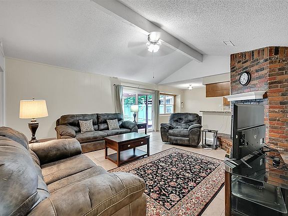 Den with wood burning fireplace opens to the kitchen, breakfast room and back yard.