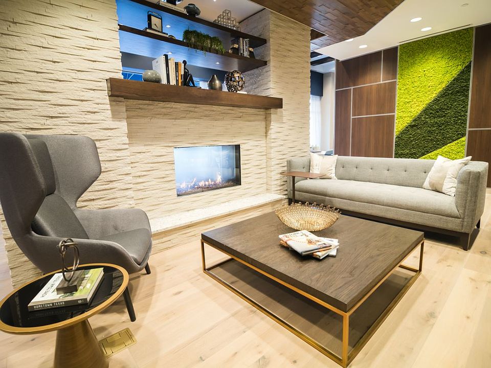 Cozy, modern resident lounge with stunning lighting, a live green wall, a fireplace, lounge seating, at TV and work space