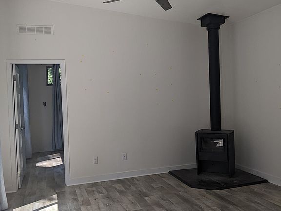 Living space with woodstove, vinyl plank floors and ceiling fan
