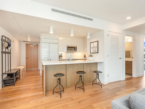 A massive, state-of-the-art kitchen with a bar, brand new appliances, custom cabinets and fridge. This is considered premium in this Azure building and not all condo units have these extreme upgrades.