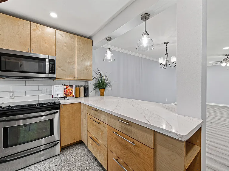 Natural wood cabinetry and quartz counter top.