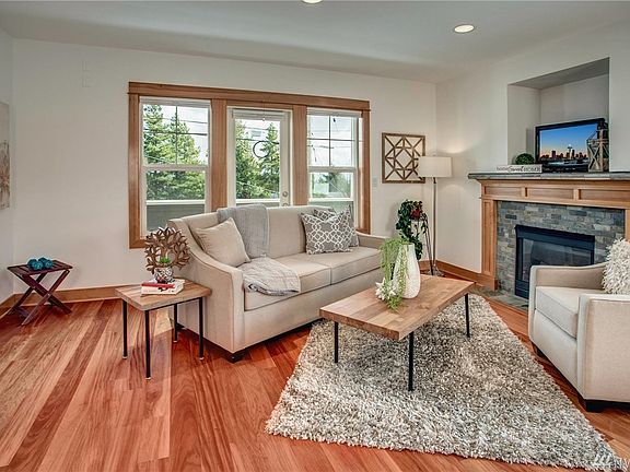 Gorgeous living room with natural light, cozy gas fireplace, hardwoods & balcony.