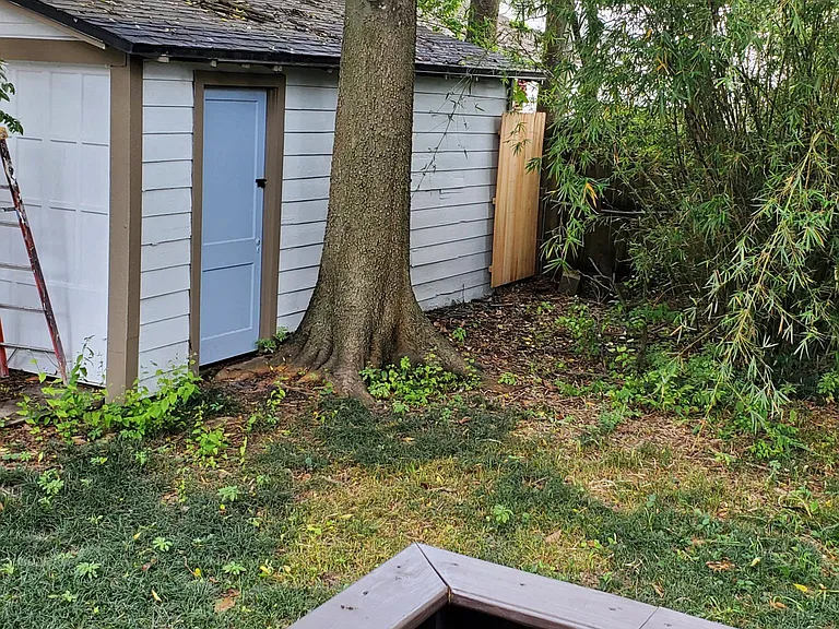 Fully fenced back yard with storage building
