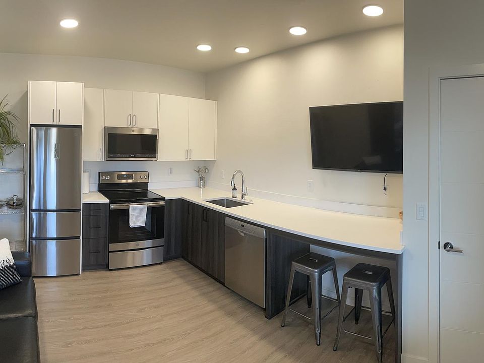 Modern Kitchen with quartz countertops, lazy susan for food storage, quiet top-rated Bosch dishwasher, 40 inch TV and entry closet for jackets and shoes.