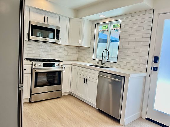 White shaker, soft closing cabinets and drawers with matte black hardware.