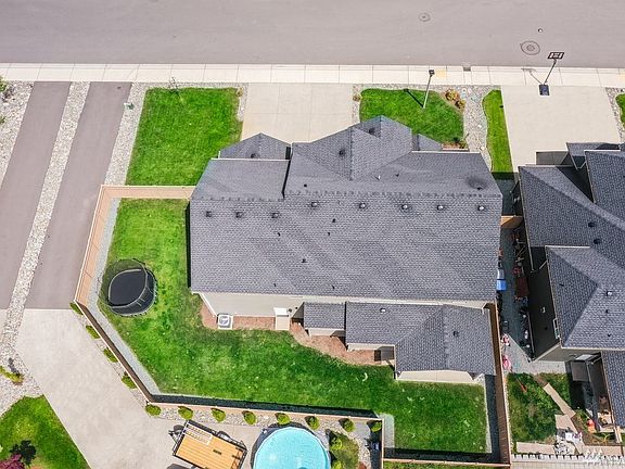 Aerial view of home shows fully fenced backyard.