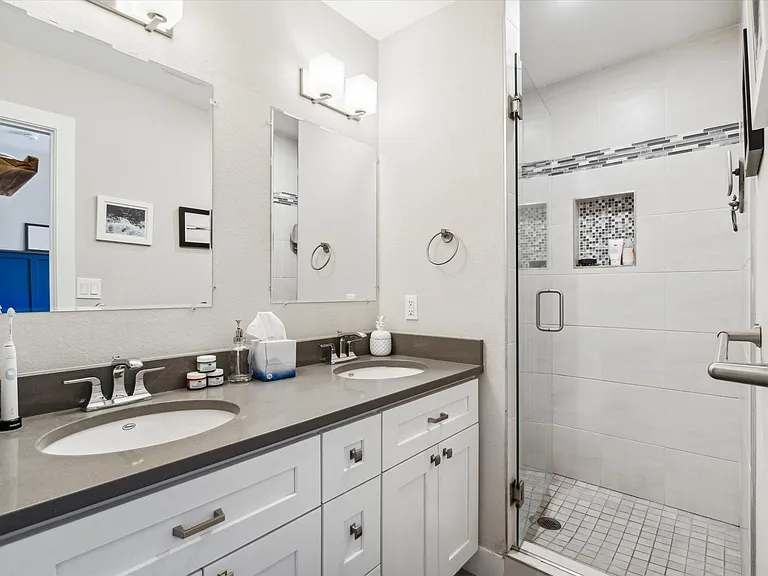 Main bathroom with double vanity and walk-in shower.