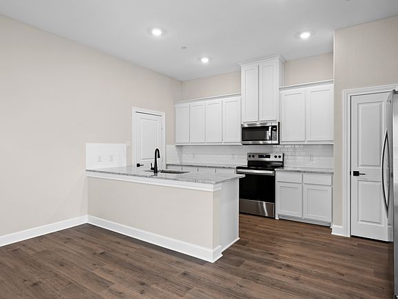 The kitchen has beautiful white wood cabinetry.