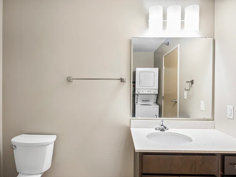 Modern bathroom with sleek vanity and in-unit washer and dryer, offering convenience and elegant design. Modern bathroom with sleek vanity and in-unit washer and dryer, offering convenience and elegant design.