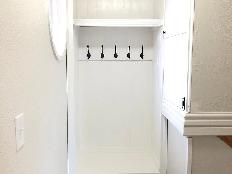 Cute beadboard closet nook in the upstairs landing. The space to the right offers ample storage.