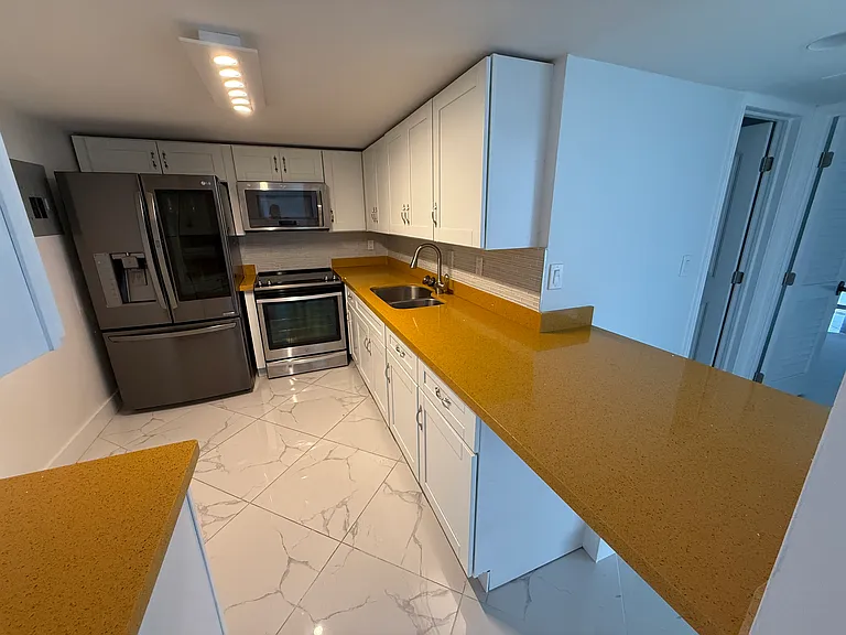 Open concept KITCHEN with limited edition custom quartz countertops, dimmable designer lighting & like-new LG & Whirlpool appliances