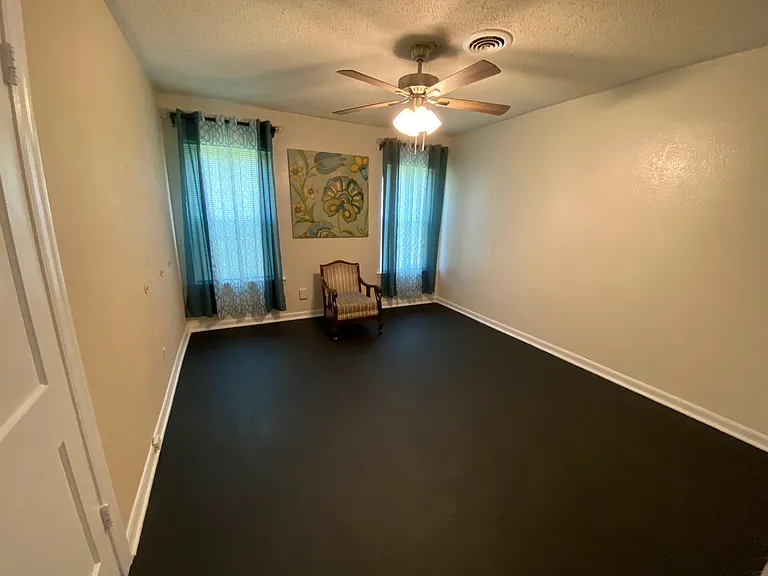 Master bedroom has two windows, ceiling fan and large closet. (chair and picture have been removed)