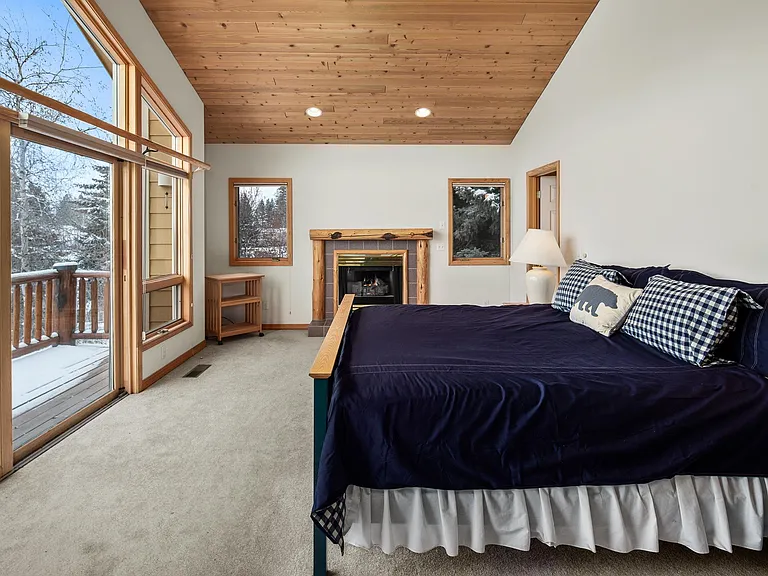 Large primary bedroom with king bed, fireplace and deck with views