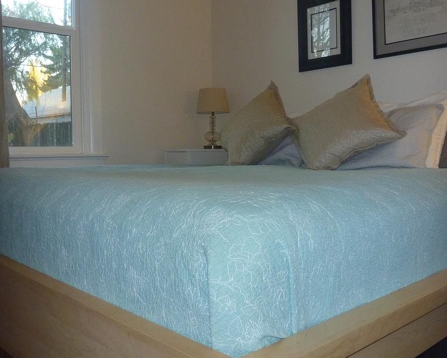 King bed with nightstands and lamps. Window overlooks backy