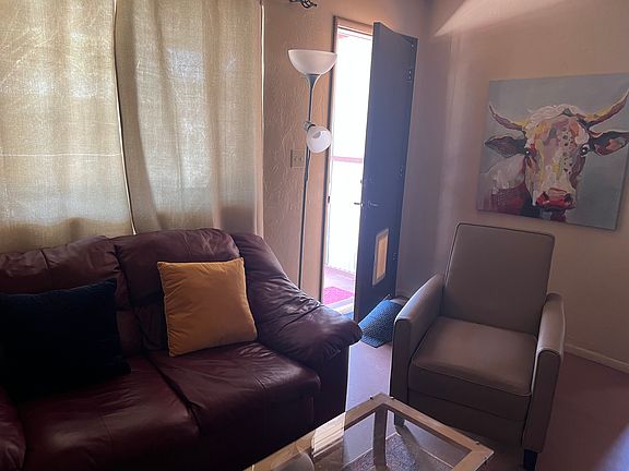 Living area with door to large, block-fenced backyard.