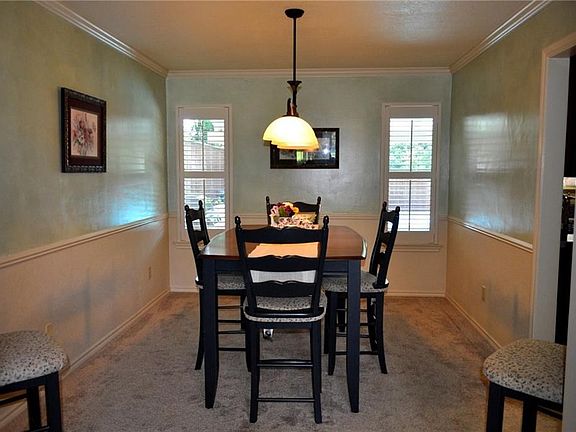 Lovely formal dining with plantation shutters and wainscoting for detail.
