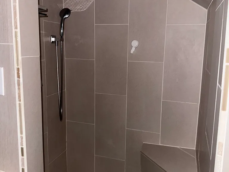 Beautifully tiled upstairs bathroom with bench, rainfall shower and wand.