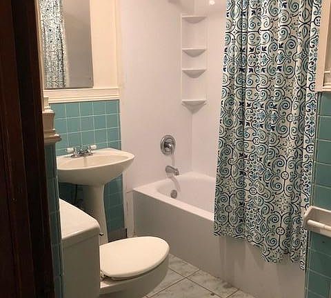 large, bright windowed bathroom with tub