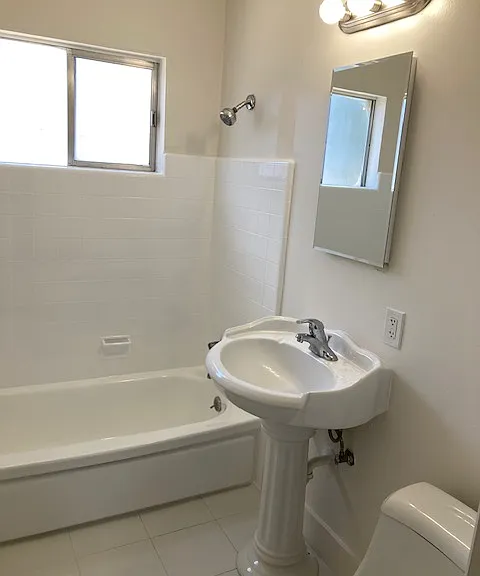 Newly refinished bathtub and tile; new shower doors installed after this photo.
