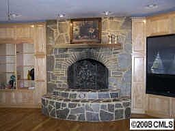 Den with stone fireplace