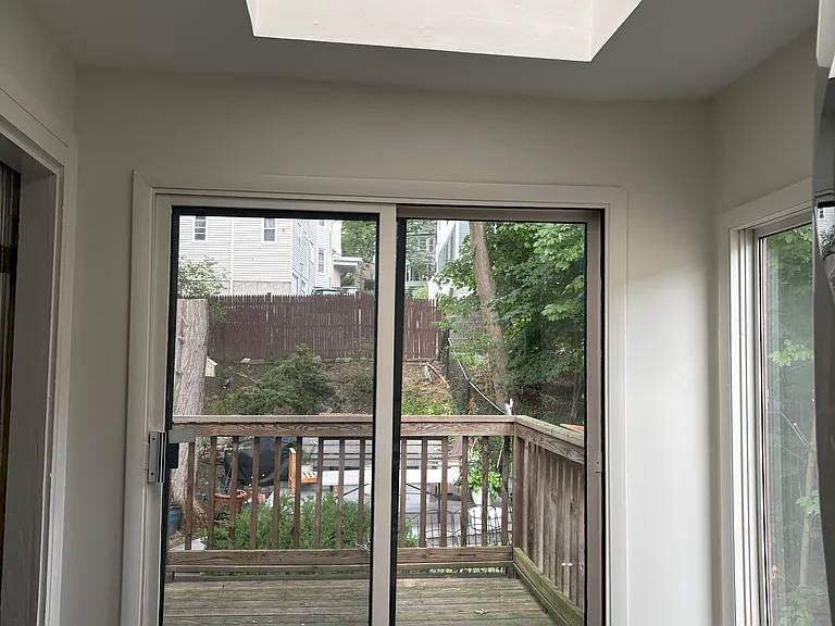 Sitting area as seen from kitchen. Seamlessly continues into a deck that overlooks the backyard. Huge skylight above sitting area.