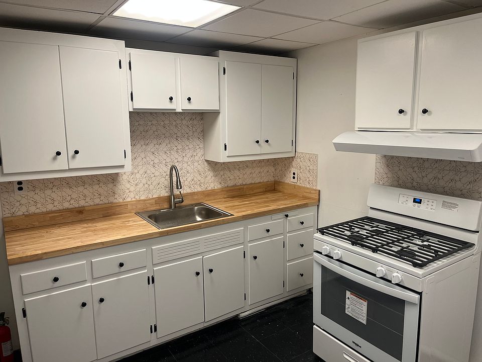 Eat in Kitchen with freshly painted cabinets, new sink, countertop and stove.